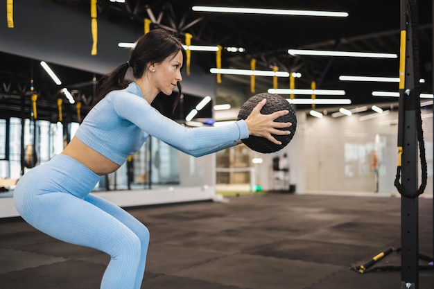 Mulher fazendo agachamento com medicine ball