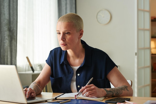 Mulher fazendo anotações durante o trabalho online