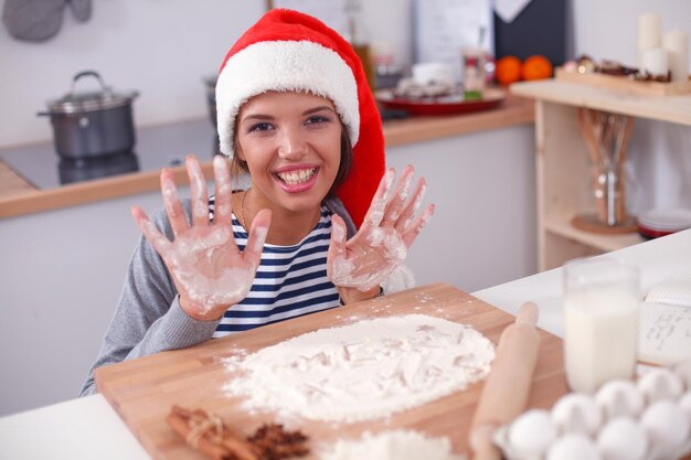 Mulher fazendo biscoitos de natal na cozinha