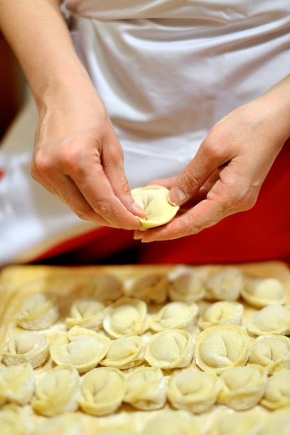 Mulher fazendo bolinhos russos pelmeni