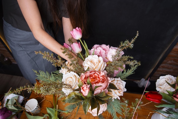 Mulher fazendo buquê de flores no escuro