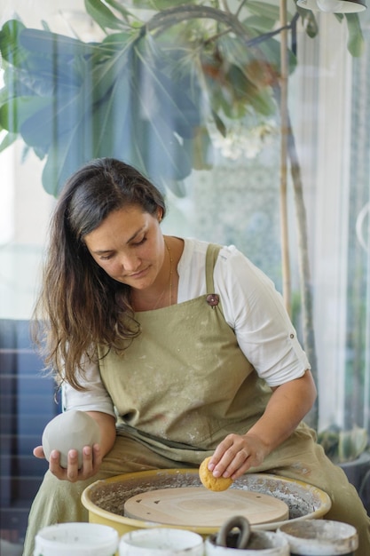 Foto mulher fazendo cerâmica na roda