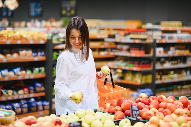 Mulher fazendo compras e parecendo muito feliz