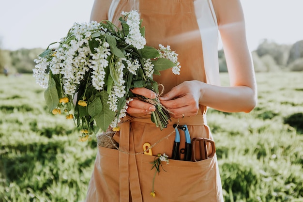 Mulher fazendo coroa de flores dentes de leão no campo florido estilo de vida de verão