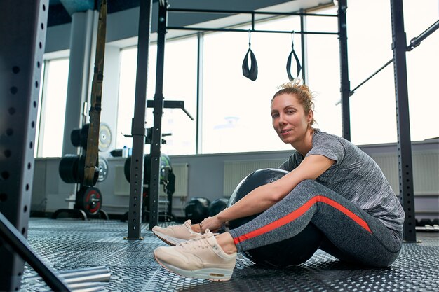 Mulher fazendo exercícios com fitball na aula de ginástica fitness.