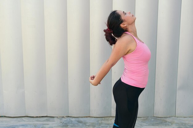 Mulher fazendo exercícios de alongamento durante treino no parque.