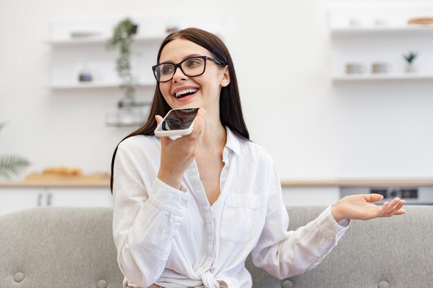 Mulher fazendo gestos enquanto grava conversa em um smartphone moderno