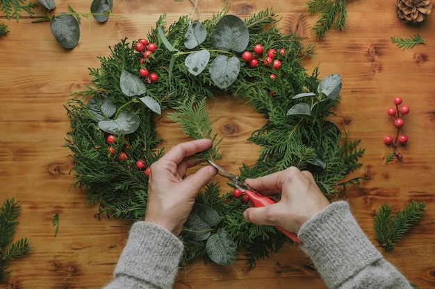 Mulher fazendo guirlanda de natal diy decoração de casa de inverno