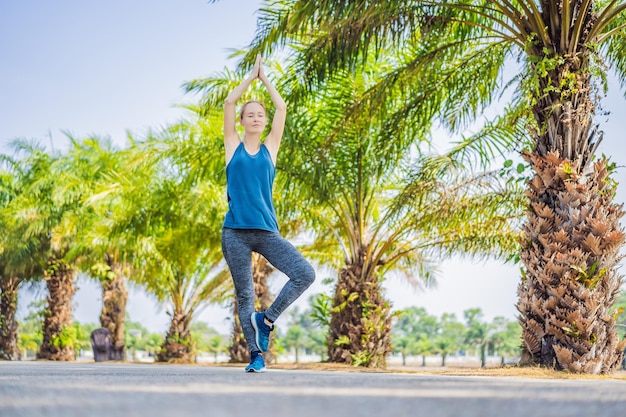 Mulher fazendo ioga em um parque tropical