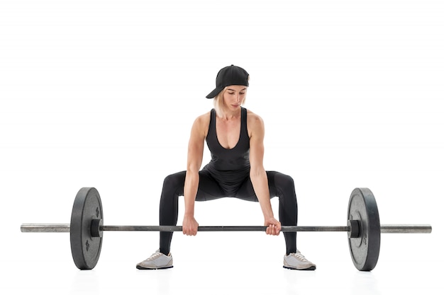 Mulher fazendo levantamento terra com um barbell isolado no fundo branco