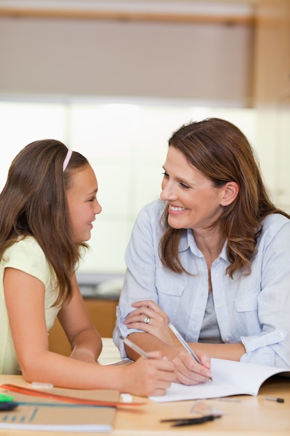 Mulher fazendo lição de casa com sua filha