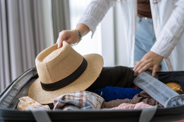Mulher fazendo mala na cama para uma nova lista de embalagem de viagem para planejamento de viagens preparando férias Reserve agora Viajando Transporte