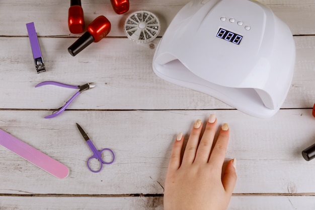 Mulher fazendo manicure acrílico bonito com lâmpada led