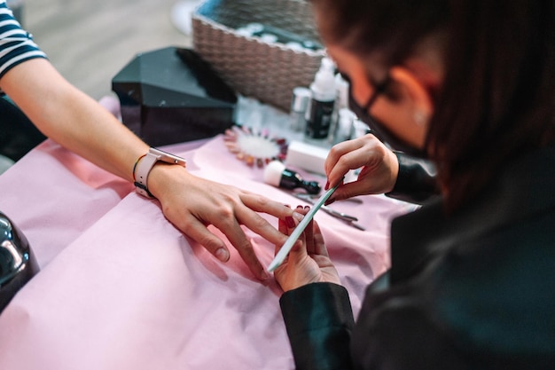 Mulher fazendo manicure no salão de beleza