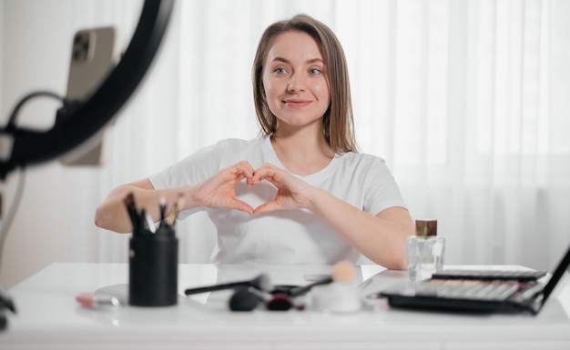 Mulher fazendo maquiagem em casa aplica cosmético decorativo
