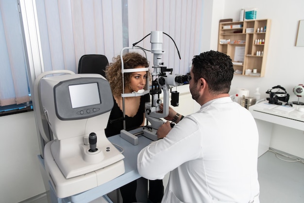 Foto mulher fazendo teste de olho com optometrista no consultório médico