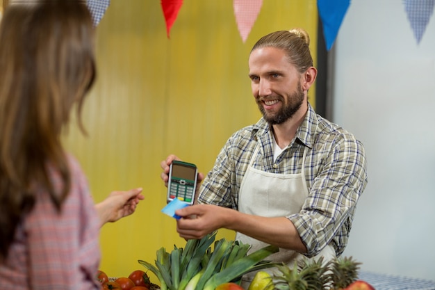 Mulher fazendo um pagamento com tecnologia NFC