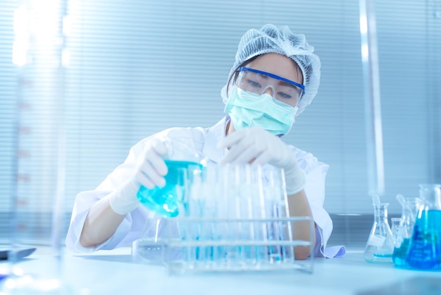 Mulher fazendo uma experiência em uma mesa de laboratório