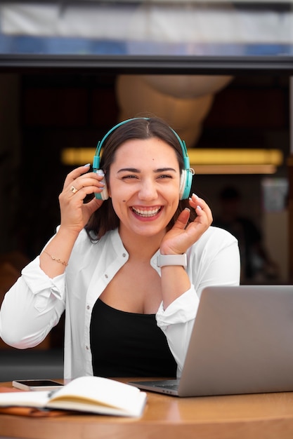 Foto mulher fazendo uma videochamada em um laptop em um café