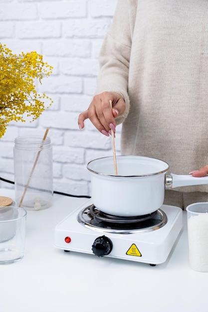 Mulher fazendo velas aromáticas decorativas na mesa fechada