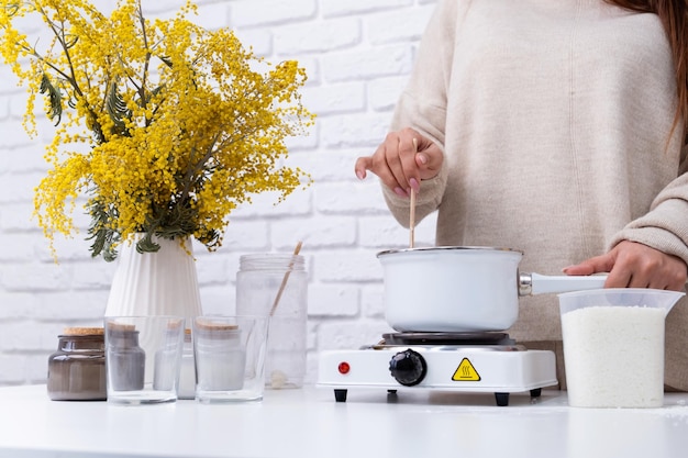 Mulher fazendo velas aromáticas decorativas na mesa fechada