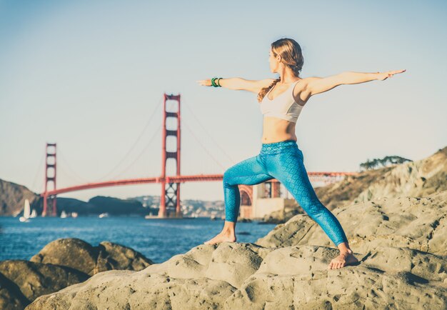 Mulher fazendo yoga na praia