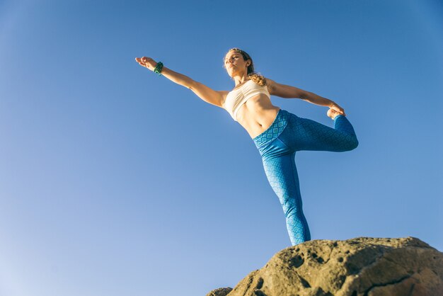 Mulher fazendo yoga na praia