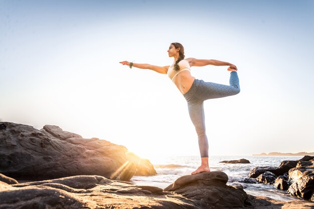 Mulher fazendo yoga na praia