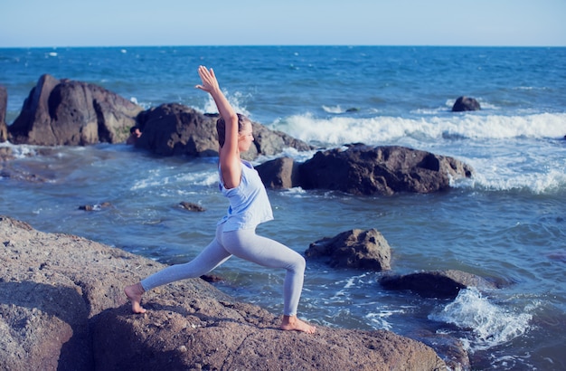 Mulher fazendo yoga na praia