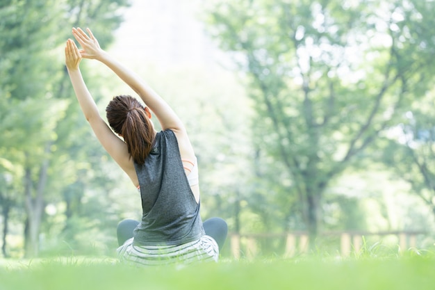 Mulher fazendo yoga no parque