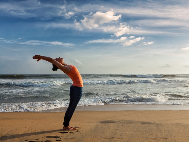 Mulher fazendo yoga saudação ao sol surya namaskar