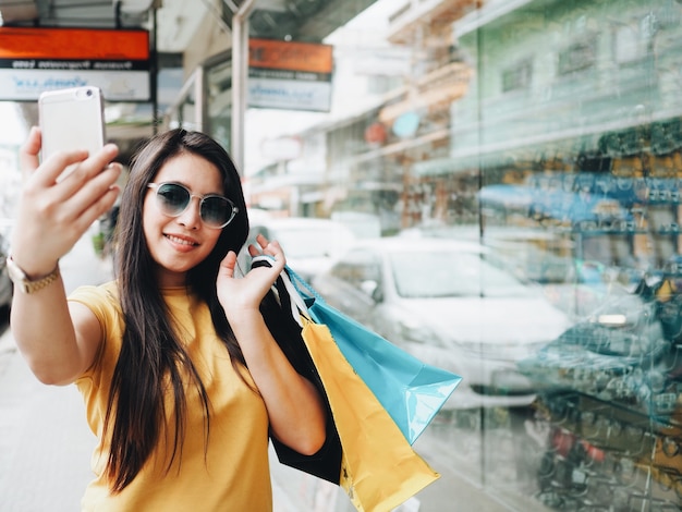 Mulher feliz alegre com as compras na rua