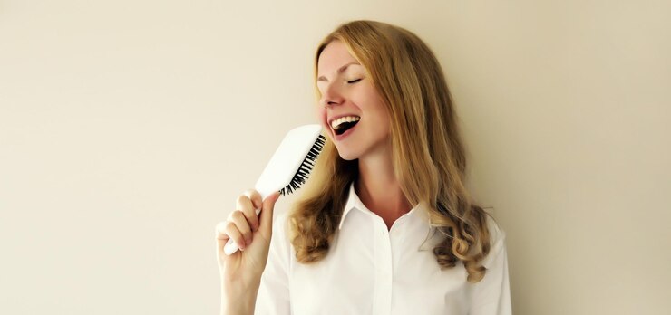 Foto mulher feliz, alegre, divertindo-se, cantando com o pente do cabelo, rindo, pronta para sair de bom humor.