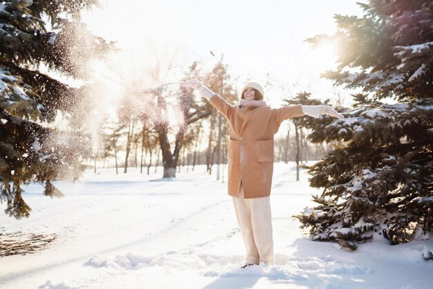 Mulher feliz andando no dia de inverno nevado ao ar livre Férias de moda de inverno descansar conceito de viagem