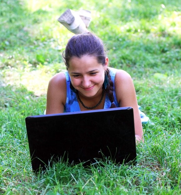 Mulher feliz ao ar livre com laptop