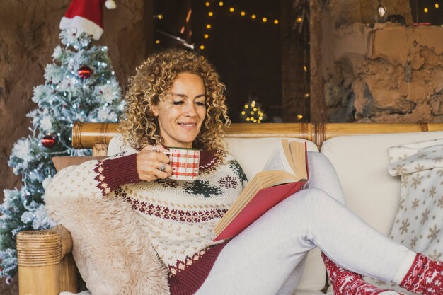 Mulher feliz aproveitando as férias de Natal relaxando em casa no sofá