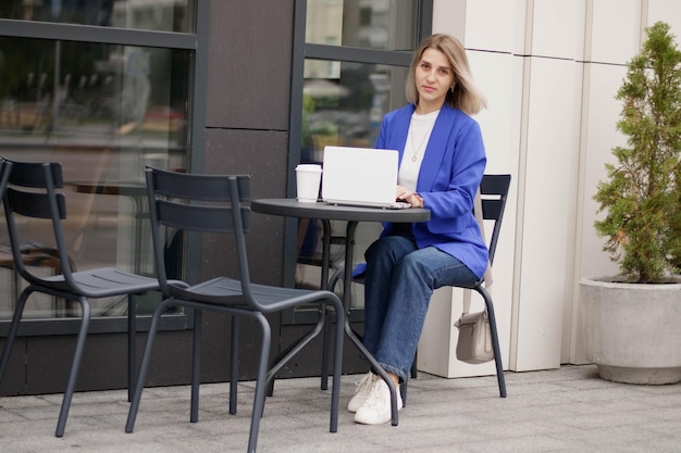 Mulher feliz assistindo conteúdo de mídia online no laptop sentado em um parque