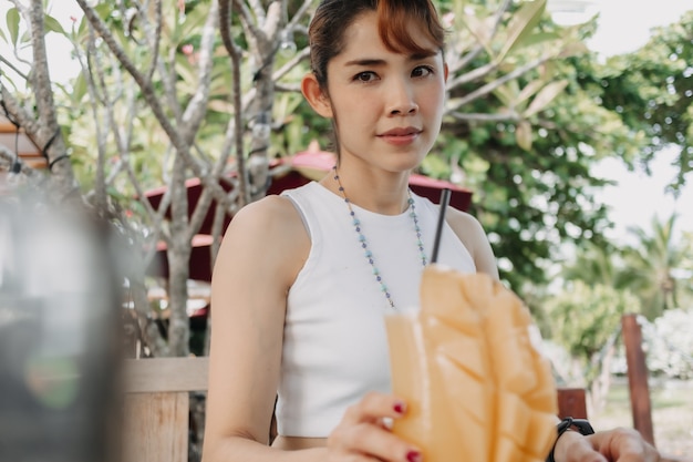 Mulher feliz bebendo suco de manga em dia de verão