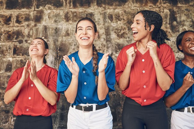 Foto mulher feliz beisebol e equipe em comemoração de aplausos ou torcida vencedora em jogo esportivo grupo de atletas femininas ou jogadoras batendo palmas na motivação do trabalho em equipe ou apoio na unidade ou sucesso de conquista