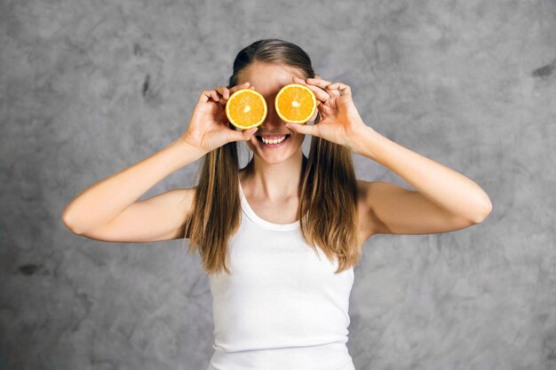 Foto mulher feliz brincando com laranjas