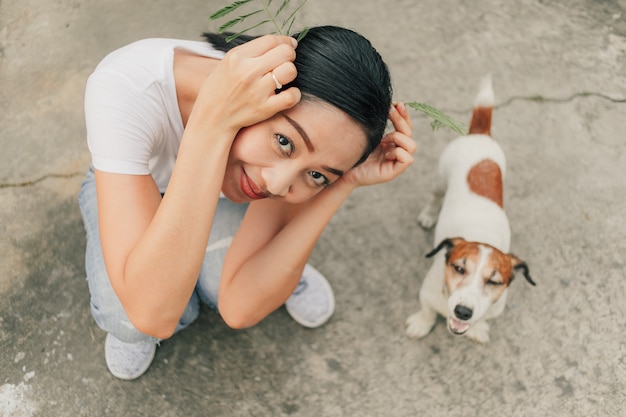 Mulher feliz brincar com o cachorro na rua.