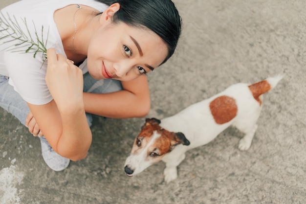 Mulher feliz brincar com o cachorro na rua.