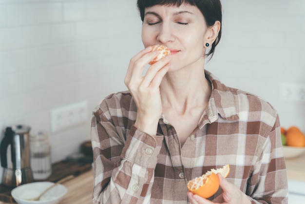 Mulher feliz cheirando frutas cítricas