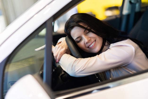 Mulher feliz cliente comprando um carro novo no centro de negociação