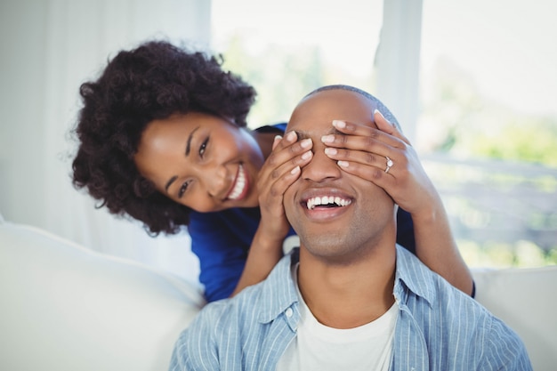 Mulher feliz, cobertura, dela, mans, olhos, com, mãos, em, a, sala de estar