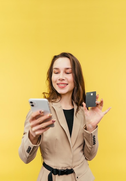 Mulher feliz com aparelho nos dentes usa um smartphone com um sorriso no rosto