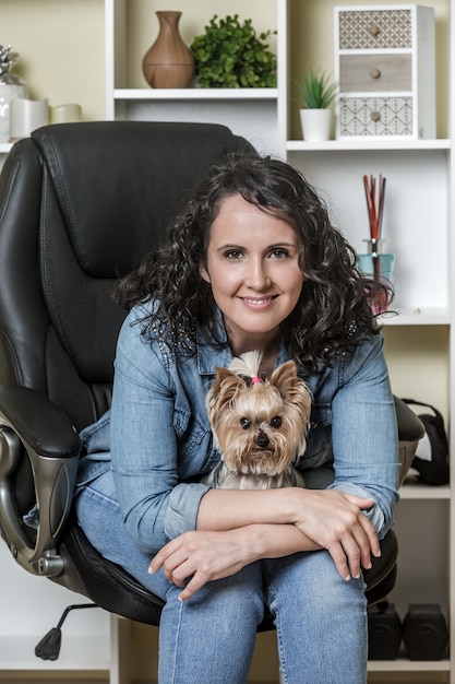 Mulher feliz com cachorro sentado na cadeira