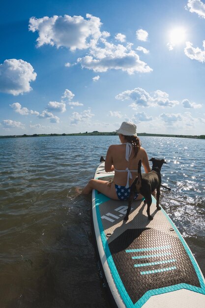 Foto mulher feliz com cão na tábua.