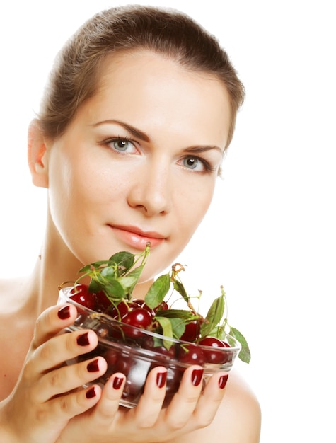 Mulher feliz com cerejas sobre branco.