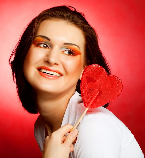 Foto mulher feliz, com, coração, doce, lolly, pop